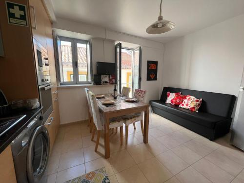 a kitchen and living room with a table and a couch at Apartamento Familia Silva in Nazaré