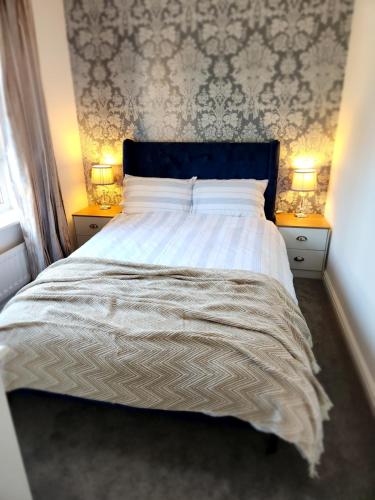 una camera da letto con un grande letto con due comodini di Beeches House - Stylish Detached house with private garden located near city centre a Sheffield