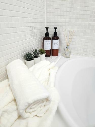 two bottles of wine sitting on a shelf in a bathroom at Modern Home2Home - Easy Centre Access & Free Parking in Sheffield
