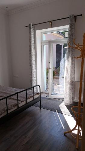 a bedroom with a bed and a sliding glass door at Castellum Apartman in Keszthely