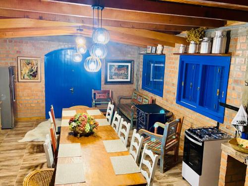 comedor con mesa, sillas y armarios azules en Cabana nas Nuvens, en São Marcos