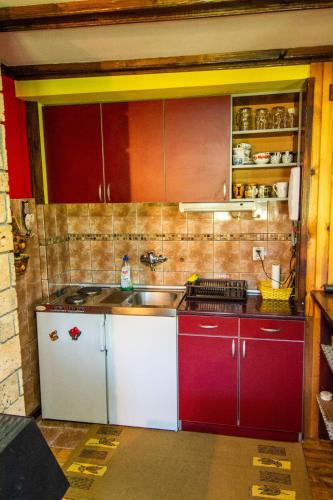 a kitchen with red and white cabinets and a sink at Vila Sara in Bajina Bašta