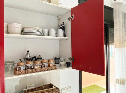 a red cabinet in a kitchen with dishes on it at Nice apartment in the city center in Marrakech