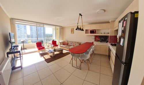 cocina y sala de estar con mesa y nevera en Laguna Bahía Algarrobo., en Algarrobo