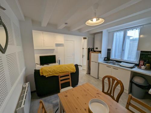 cocina y sala de estar con sofá y mesa en Appartements avec terrasse proche métro - Paris à 25min, en Créteil