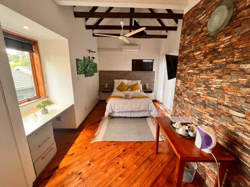 a bedroom with a bed and a brick wall at The Wood House in Empangeni