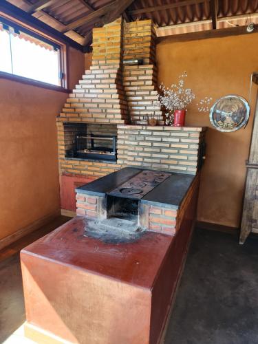 cocina con estufa de ladrillo en una habitación en Chales Sitio dos Ventos en Lavras Novas