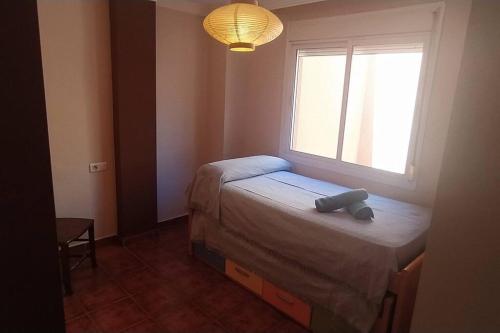 - une petite chambre avec un lit et une fenêtre dans l'établissement Casa en Málaga, à Malaga