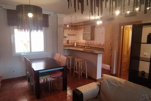 Il comprend un salon avec une table et une cuisine. dans l'établissement Casa en Málaga, à Malaga