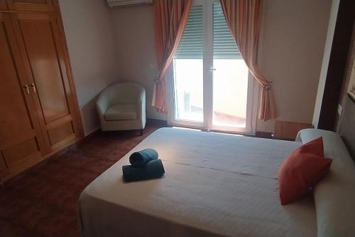 - une chambre avec un grand lit et une grande fenêtre dans l'établissement Casa en Málaga, à Malaga