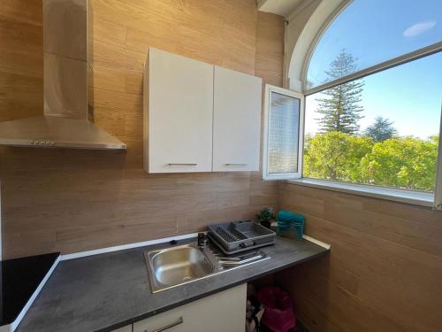塞圖巴爾的住宿－Suites DP Setúbal，厨房设有水槽和窗户。