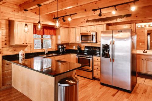 La cuisine est équipée d'armoires en bois et d'un réfrigérateur en acier inoxydable. dans l'établissement Expansive Mountain Views, Theater, Games, Hot Tub, Relaxing porches, à Sevierville