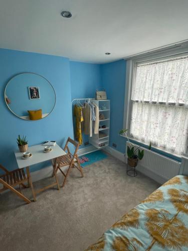 una camera con letto, tavolo e specchio di Studio Pillo Hammersmith a Londra