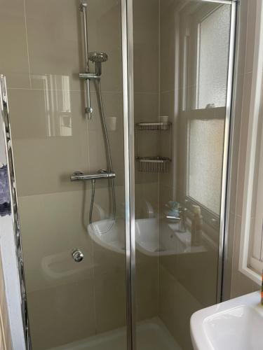 a shower with a glass door next to a sink at Studio Pillo Hammersmith in London