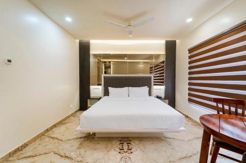 a bedroom with a large white bed and a desk at Palette - Coastal Grand Hotels & Resorts, OMR in Chennai