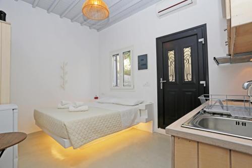 Habitación blanca con cama y lavamanos en Brand New Mykonos Town Suites, en Mykonos ciudad
