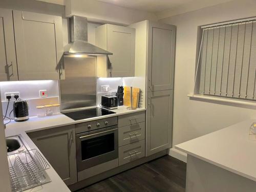uma cozinha com fogão forno ao lado de um lavatório em Newly Refurbished Apartment with private parking em Southampton