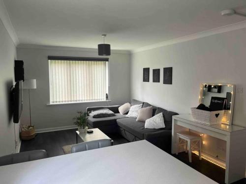 een woonkamer met een bank en een tafel bij Newly Refurbished Apartment with private parking in Southampton