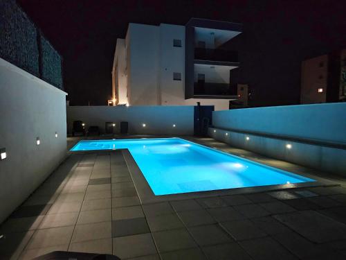 una piscina sul tetto di un edificio di notte di West Star Apartment a Trogir