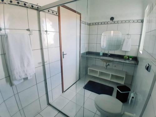 e bagno con doccia, servizi igienici e specchio. di Casa central aconchegante a Alto Paraíso de Goiás