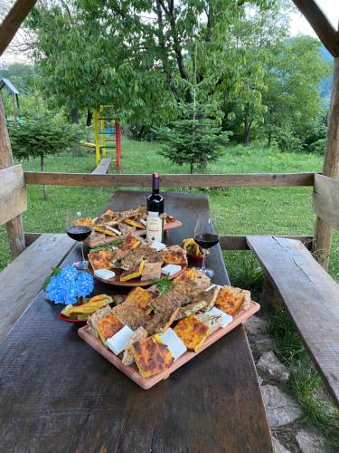 stół piknikowy z jedzeniem i winem w obiekcie Guesthouse Makry w mieście Pukë