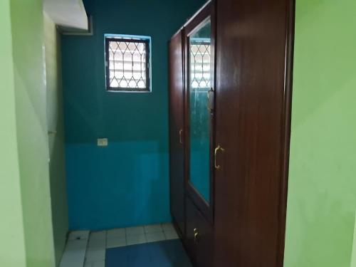 a hallway with a wooden door and a blue wall at Safe Home Stay in Cansaulim