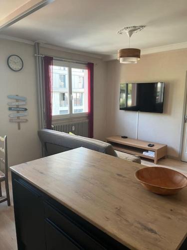 - un salon avec une table en bois et un bol dans l'établissement Appartement cosy Gare St-Etienne, à Saint-Étienne
