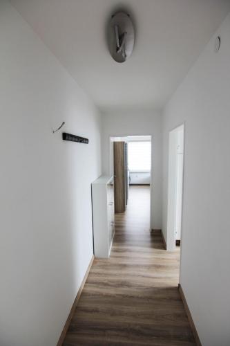 an empty hallway with white walls and wood floors at Appartement in Pattensen in Pattensen