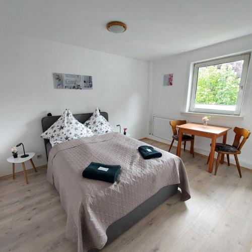 een slaapkamer met een bed, een tafel en een raam bij Hotel 24 in Bilstein