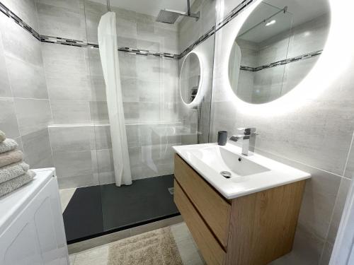 W białej łazience znajduje się umywalka i lustro. w obiekcie Chalereux studio a la montagne w mieście Auron