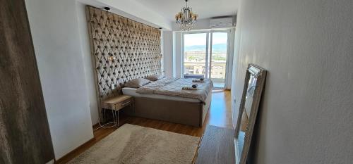 um quarto com uma cama num quarto com uma janela em Mr.-Legend's Penthouse em Skopje