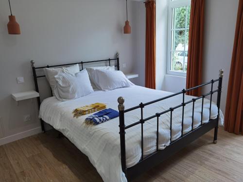 une chambre avec un lit avec des draps blancs et une fenêtre dans l'établissement La maison margalaise, à Margaux