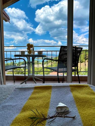 a table and chair on a balcony with a view of the ocean at Villa Chingo in Ohrid