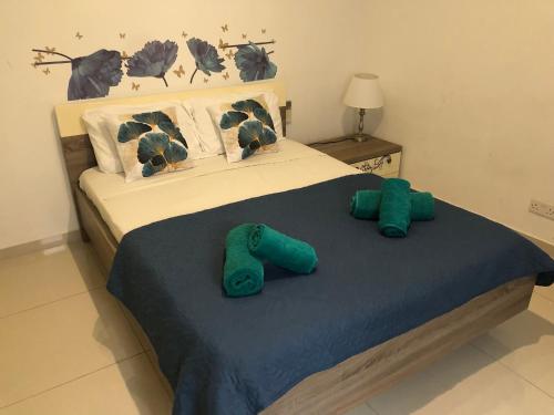 - une chambre avec un lit et des serviettes vertes dans l'établissement Camera centrale a pochi passi da Paceville e San Giuliano, à Is-Swieqi