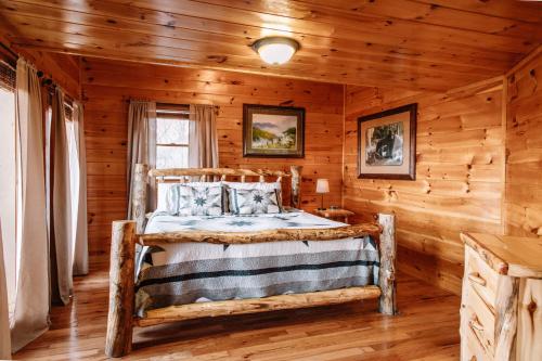 1 dormitorio con 1 cama en una cabaña de madera en Expansive Mountain Views, Theater, Games, Hot Tub, Relaxing porches en Sevierville