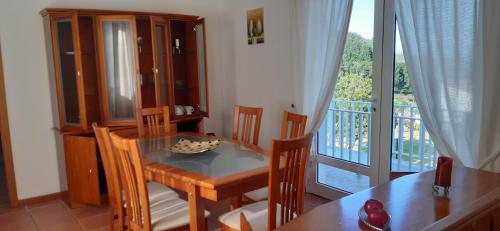 a dining room with a table and a balcony at Casinha do Chorão in Ribeirinha