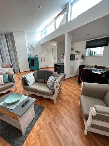 una sala de estar con 2 sofás y un piano en Sander's Apartments Landstuhl, en Landstuhl