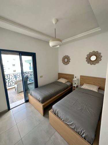 Appartement Costa Mar Martil-Tetouan في مرتيل: غرفة نوم بسريرين وشرفة