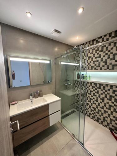 La salle de bains est pourvue d'un lavabo et d'une douche. dans l'établissement Appartement Costa Mar Martil-Tetouan, à Martil