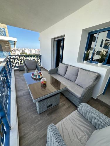 a living room with a couch and a table on a balcony at Appartement Costa Mar Martil-Tetouan in Martil