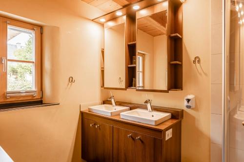 a bathroom with two sinks and a shower at Alm Chalet Grosseck in Mariapfarr