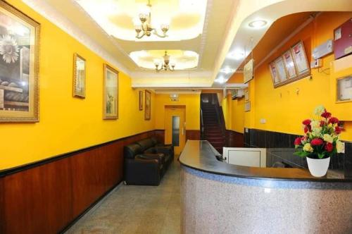 una sala de espera con paredes amarillas y un bar en Bab Al Bahrain Hotel en Manama
