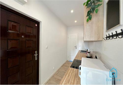 eine Küche mit einer braunen Tür und einer Arbeitsplatte in der Unterkunft August Room in Danzig