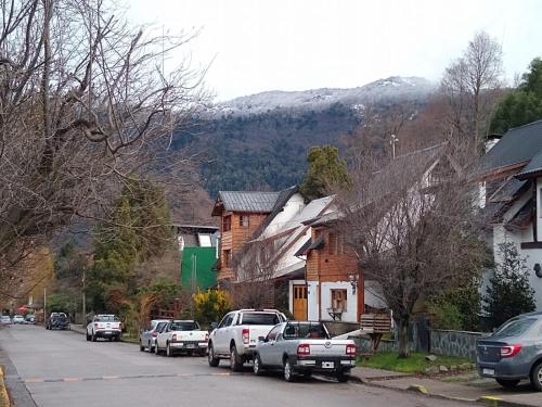 a street in a town with cars parked on the street at Casa Cipres in San Martín de los Andes