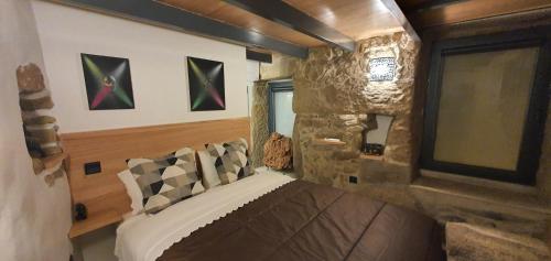 a bedroom with a bed in a room with a stone wall at Casa Fina in São Pedro do Sul