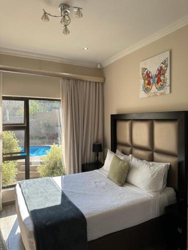 a bedroom with a bed and a large window at RNB Guesthouse in Roodepoort