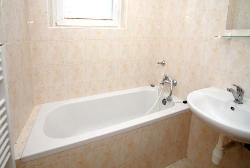 a bathroom with a white tub and a sink at Penzion a ubytovna Oáza in Otrokovice