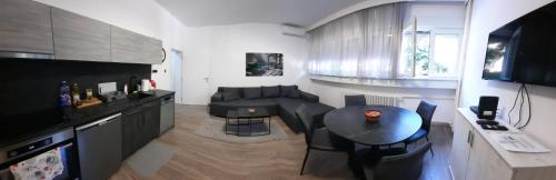 ein Wohnzimmer mit einem Tisch und einem Sofa in der Unterkunft Apartman PAVLOVIC 1 in Dedinje