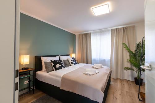 um quarto com uma cama grande e uma janela em CARICASA Stylisches Apartment in der Nähe von Nürnberg em Schwarzenbruck