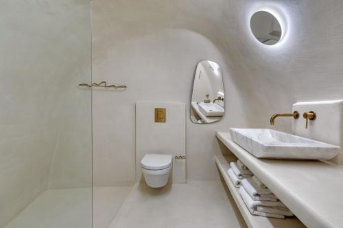 un bagno bianco con un water e un lavandino di Kore Cave House by Oias Local Cave Houses a Oia